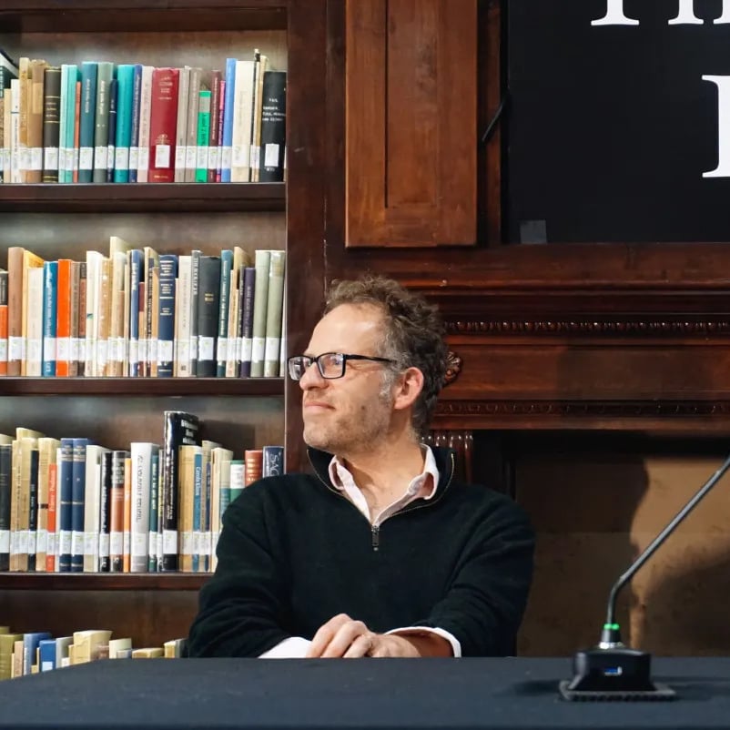 Panel member sitting in a library setting