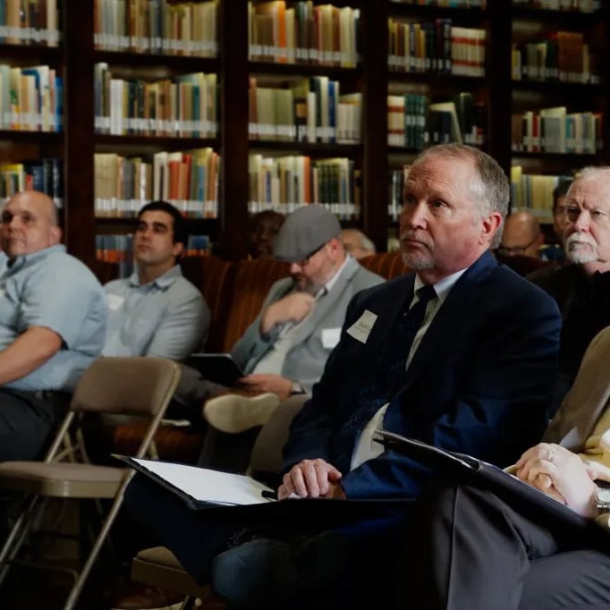 Audience sitting in a library setting
