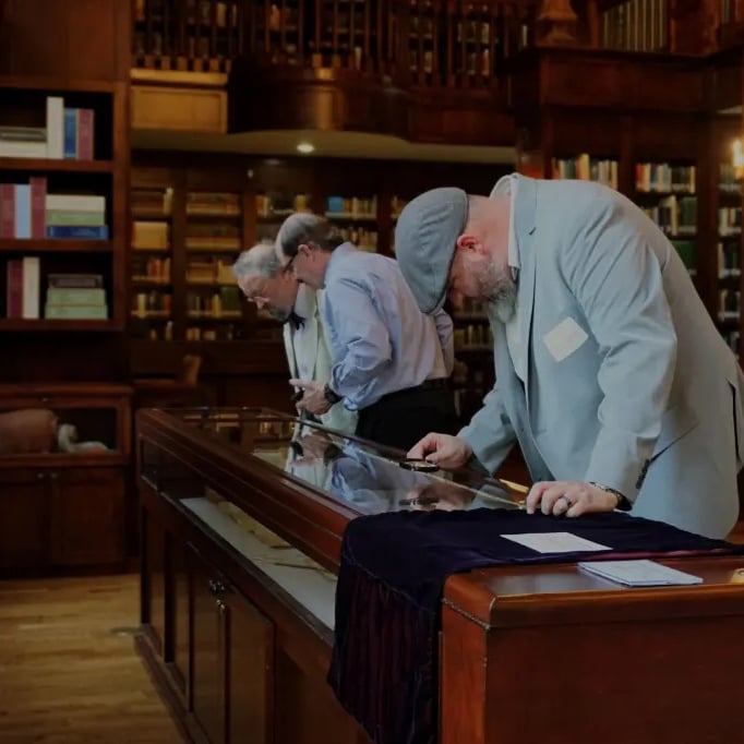 Group of men examining books or manuscripts