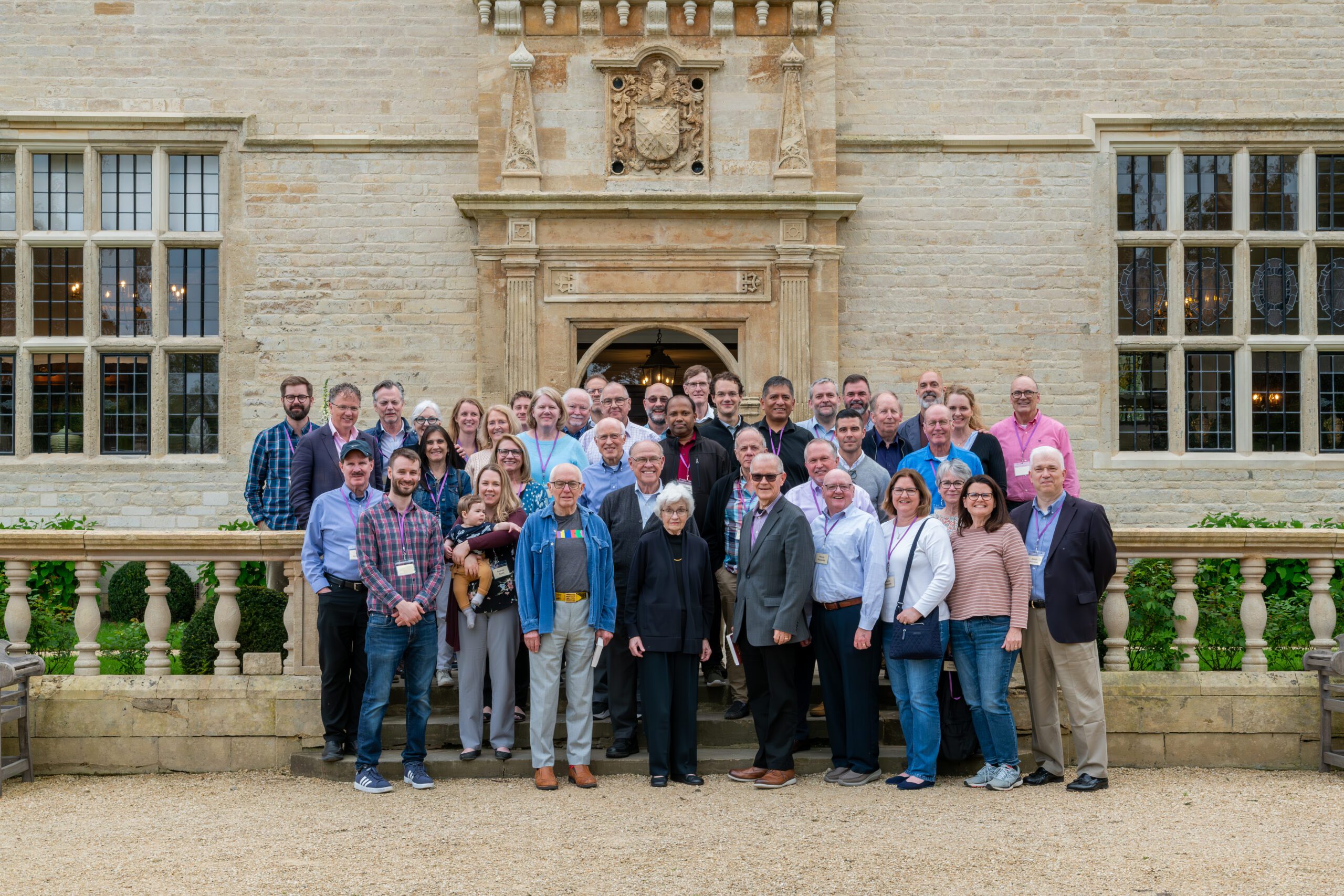 Large group photo outside of a stone building